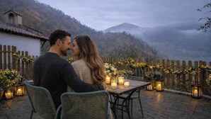 A couple seated at a table with candles, overlooking a mountainous landscape. - Romantic place with Jacuzzi, fantastics mountain Views And Fireplace (Asturias)