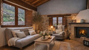 A cozy living room with a fireplace, a sofa, a chair, and a coffee table. - Romantic place with Jacuzzi, fantastics mountain Views And Fireplace (Asturias)