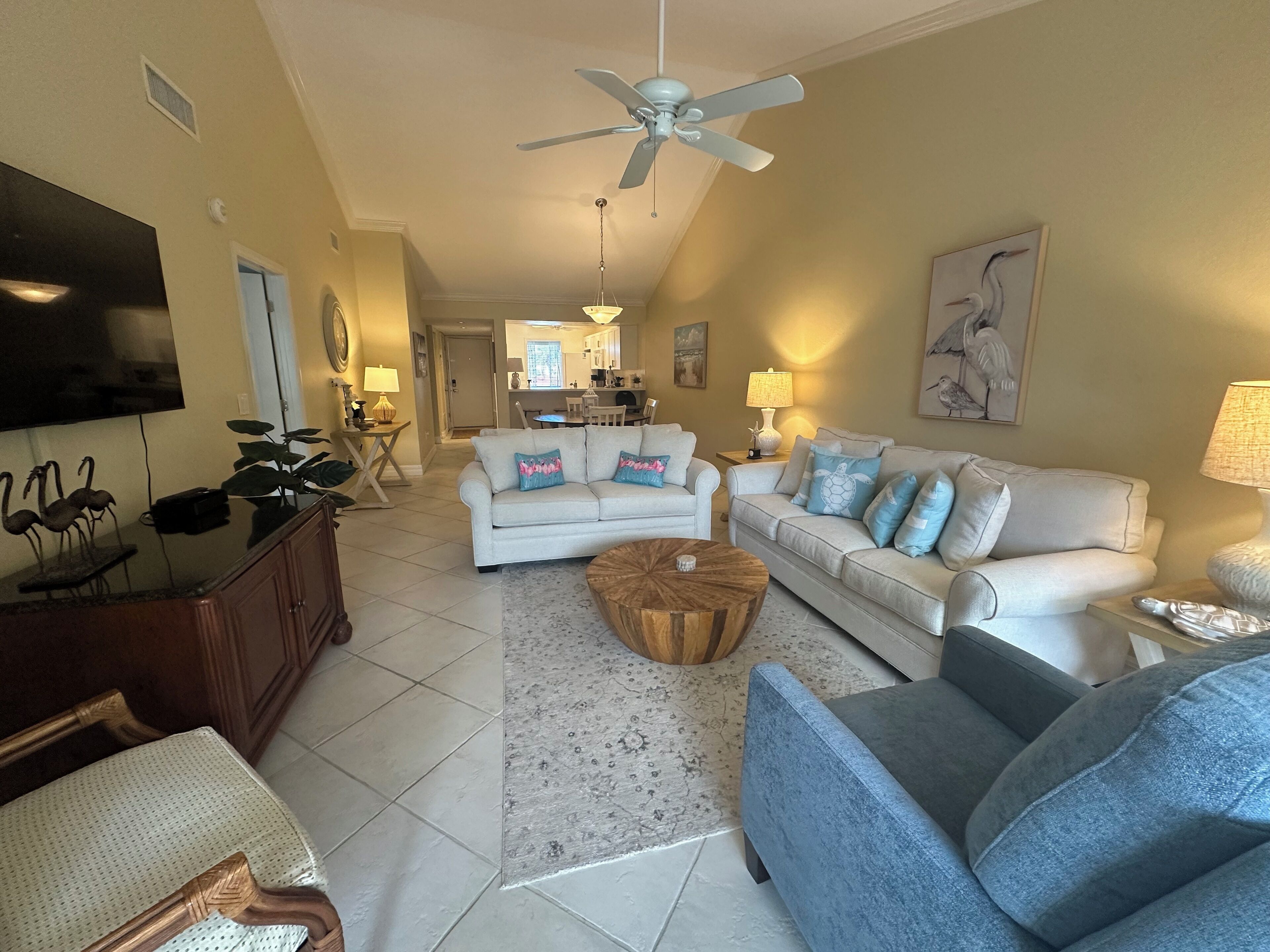 A living room with a ceiling fan, two couches, a coffee table, and a TV.