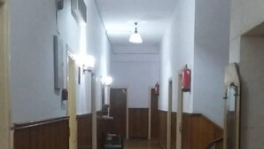 A narrow hallway with wooden paneling on the walls, a tiled floor, and a ceiling light fixture. - De La Poste (Port Said)