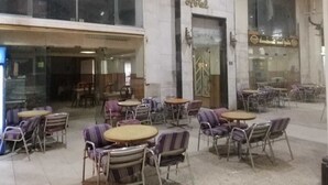 A hotel exterior with outdoor seating, a large entrance, and a sign indicating the hotel's name. - De La Poste (Port Said)