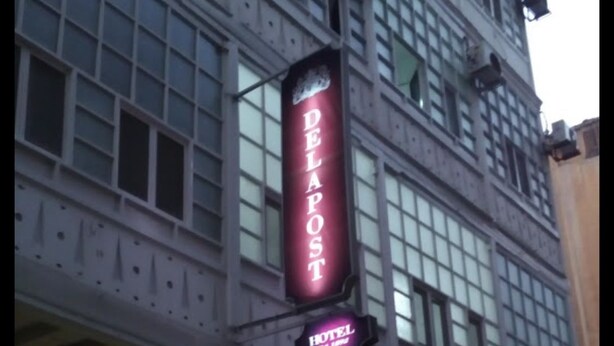 A hotel named "Delapost" with a modern facade and a sign indicating it is a hotel.