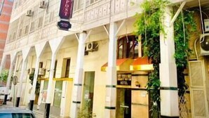 A hotel with a classic architectural style, featuring multiple windows and a central entrance.