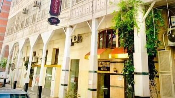 A hotel with a classic architectural style, featuring multiple windows and a central entrance. - De La Poste (Port Said)