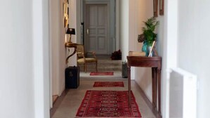 A hallway with a carpeted floor, a wooden bench, and a door at the end. - Camino Home (Cluj-Napoca)