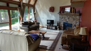 A living room with a stone fireplace, a television, and a sofa. - Lakefront spacious contemporary. Large families welcome. Ski GORE nearby! (Chestertown)