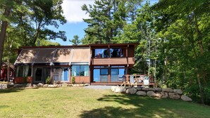 A two-story house with a large front porch, stone wall, and a well-maintained lawn. - Lakefront spacious contemporary. Large families welcome. Ski GORE nearby! (Chestertown)