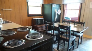 Une cuisine de taille réduite équipée d’une cuisinière, d’un four à micro-ondes et d’un réfrigérateur.