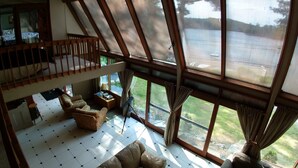 A spacious living area with a high ceiling, large windows, and a balcony. - Lakefront spacious contemporary. Large families welcome. Ski GORE nearby! (Chestertown)