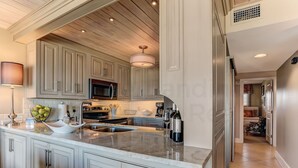 A spacious kitchen with a large island, stainless steel appliances, and light gray cabinetry.