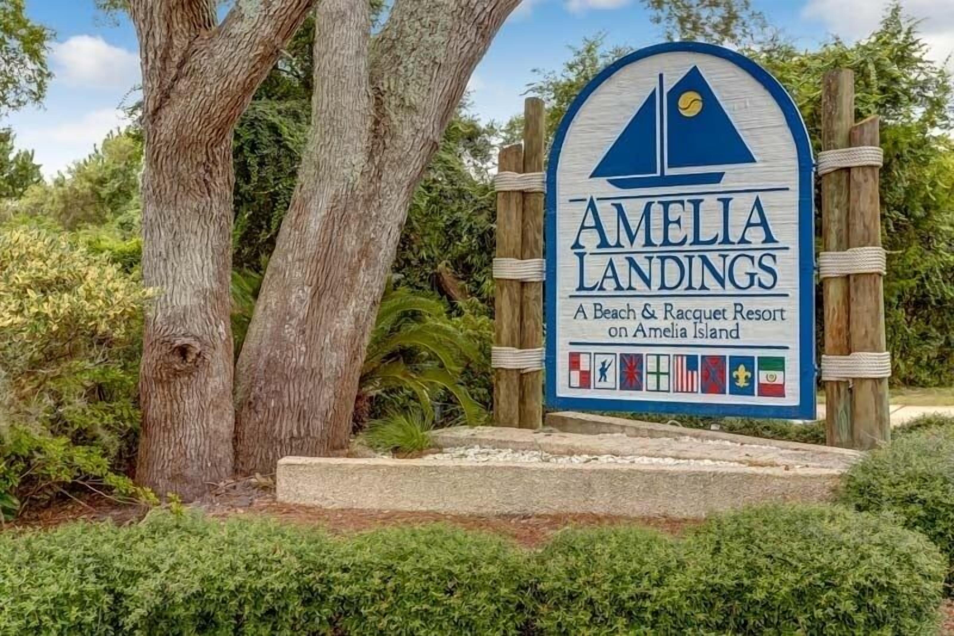 Placa de Amelia Landings, um resort de praia e quadras esportivas em Amelia Island, com bandeiras indicando diversos serviços.