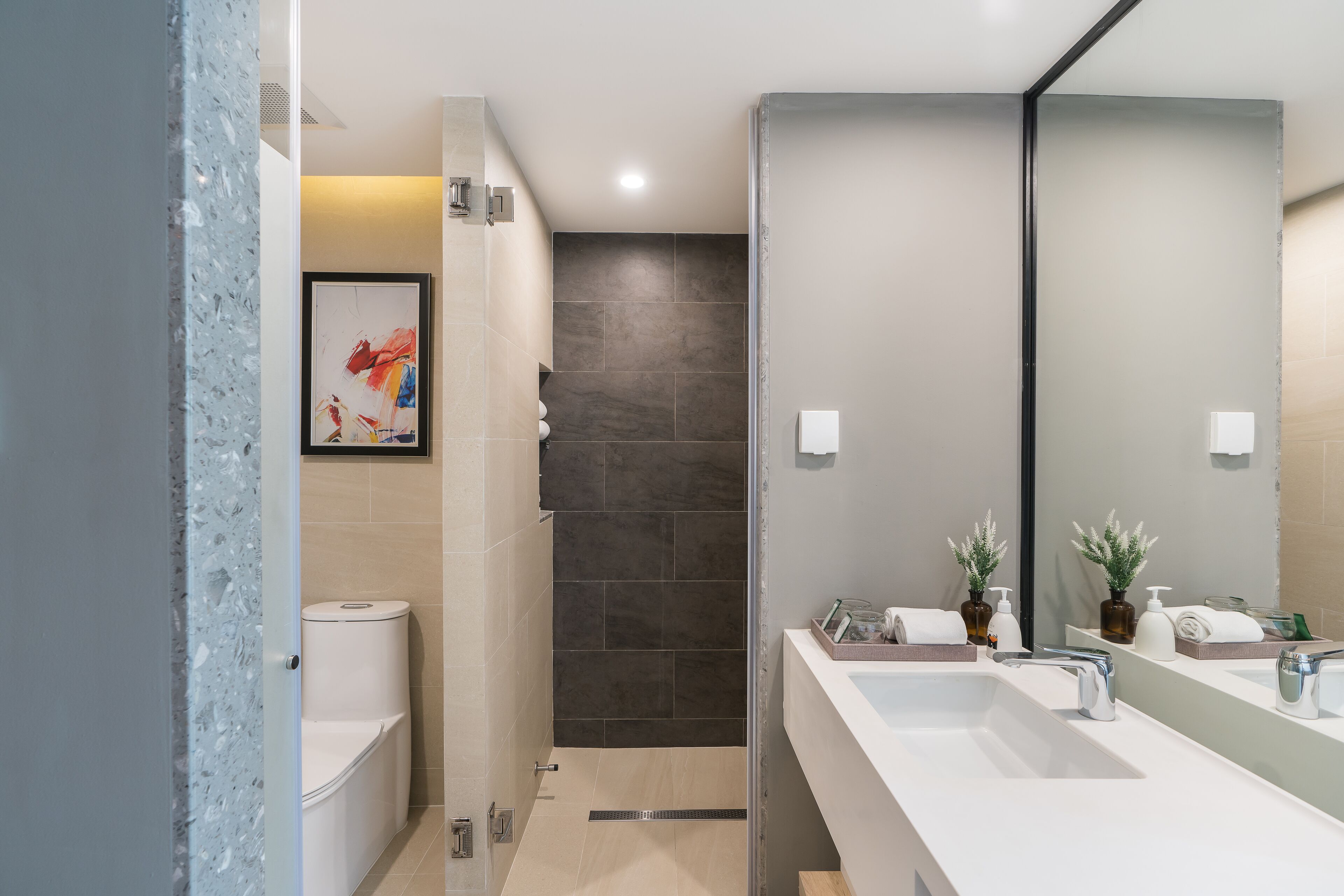 A modern bathroom with a shower, toilet, and dual sinks.