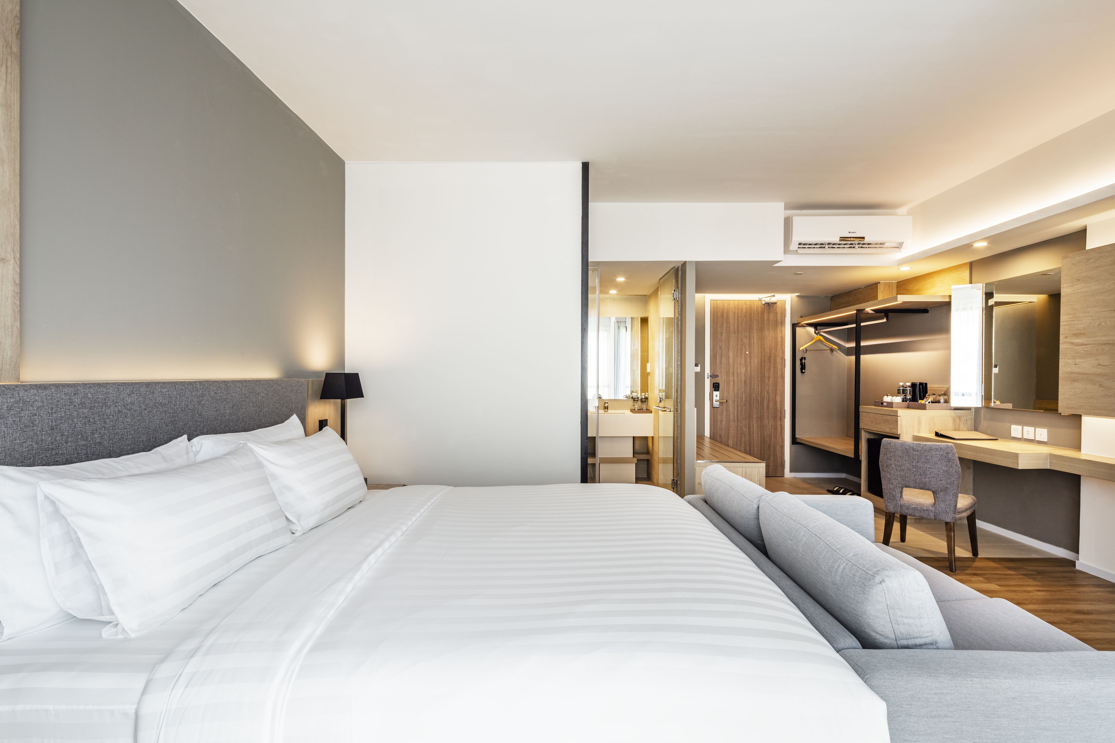 Ein modernes Hotelzimmer mit einem großen Bett, einem Schreibtisch und einem Stuhl.