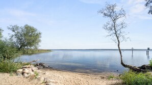 A calm lake with clear water, surrounded by sandy shores and sparse vegetation. - Plau Lagoons (Plau am See)