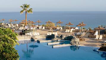 Alberca techada, 3 albercas al aire libre y sombrillas en la alberca