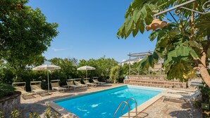 A swimming pool with lounge chairs and umbrellas, surrounded by greenery and stone flooring. - 2 BEDROOM APARTMENT WITH A VIEW OF THE GULF OF NAPLES (Sant'Agnello)