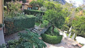 A stone staircase leading up to a building surrounded by lush greenery and a well-maintained garden. - 2 BEDROOM APARTMENT WITH A VIEW OF THE GULF OF NAPLES (Sant'Agnello)