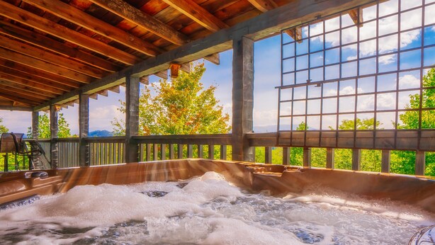 A hot tub with a wooden ceiling and a view of trees and mountains. - 🐻Beau Voir🚡 Beautiful Views, Game Loft, Great Location, & Hot Tub (Sevierville)