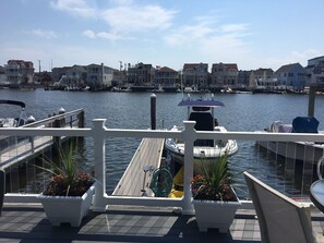 A marina with docked boats, a wooden deck, and potted plants.