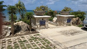 Stunning coastal views greet you at Cotton Day Sea Windsor's entrance, where palm trees and lush vegetation surround a beautifully paved area.