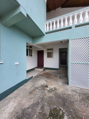Simple, utilitarian building with a flat roof and balcony.
