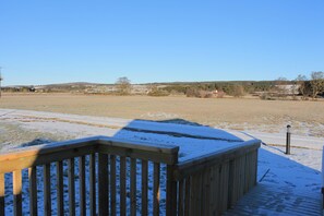 A wooden deck with snow on the ground and a clear view of a distant landscape. - Evelix Pods (Dornoch)