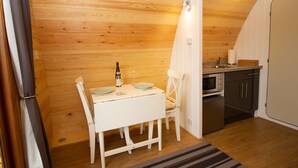Cocina compacta con una mesa blanca, sillas y comedor.