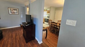A living room with a dark wooden cabinet, a television, and a framed picture on the wall.