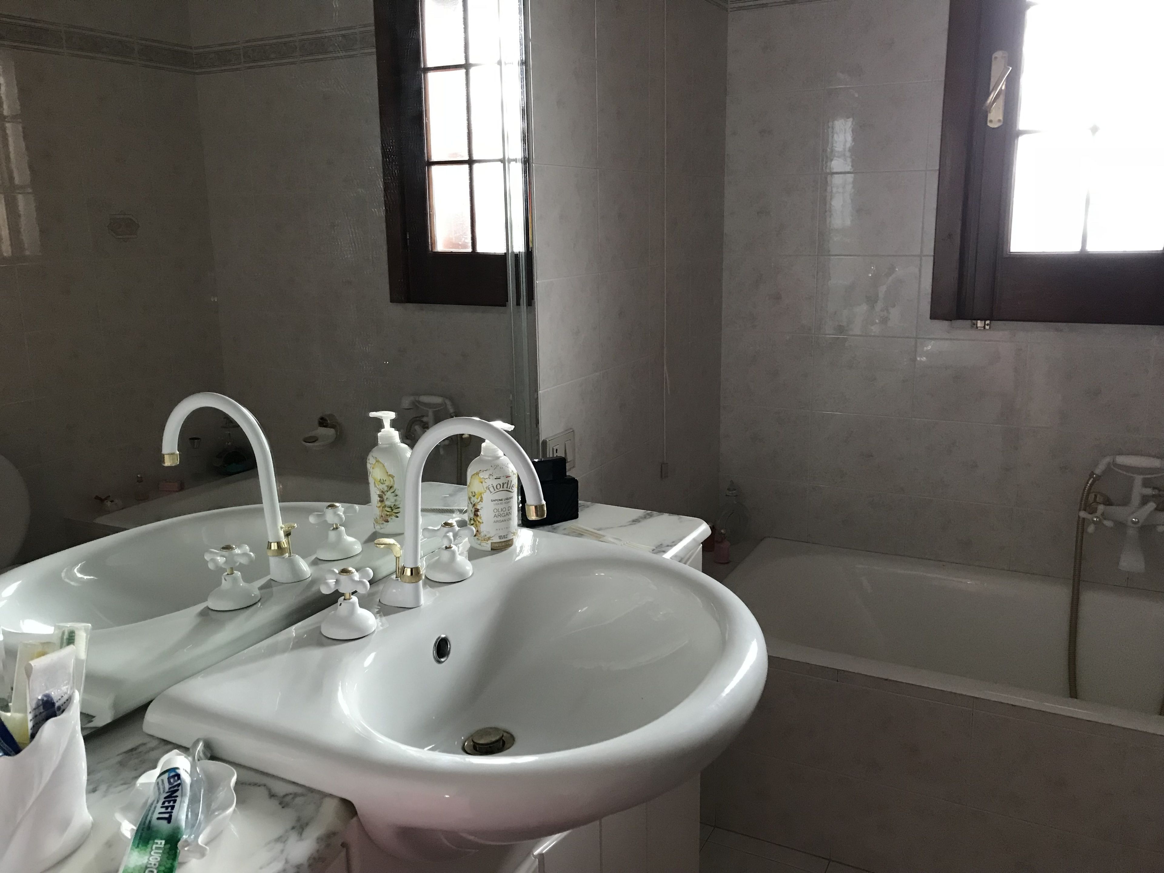 Un bagno con due lavandini, uno specchio e una vasca.