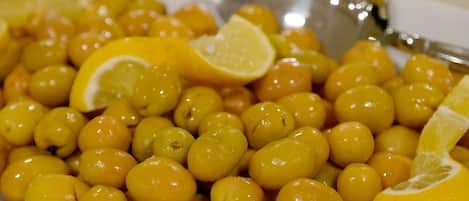 Un plato blanco con aceitunas amarillas y rodajas de limón.
