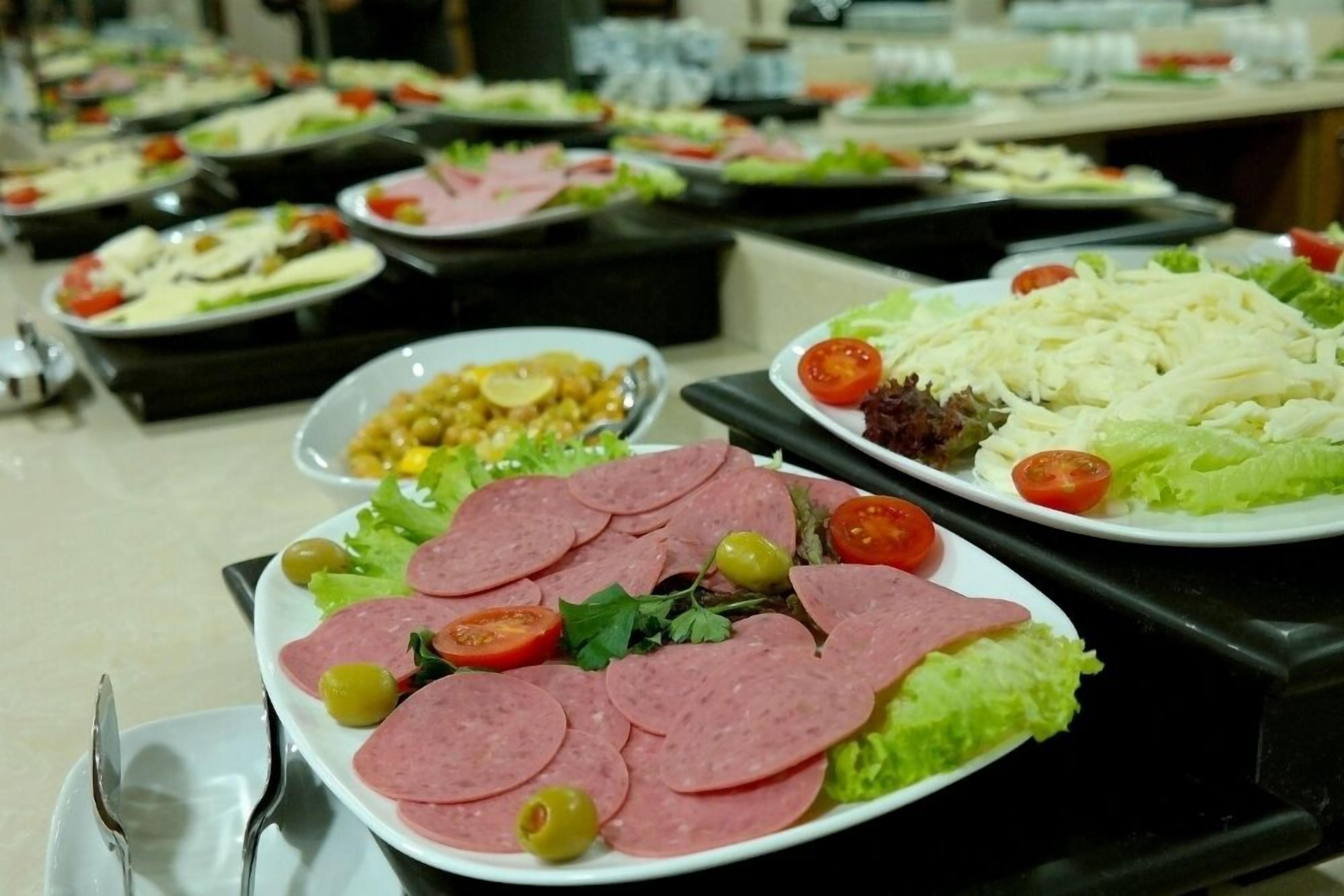 Un buffet con diversi piatti, tra cui salumi, insalate e verdure.