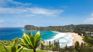 A coastal view with a beach, ocean, and a town in the background. - The Elysium by Contemporary Hotels (Palm Beach)