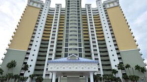 Un hotel de varios pisos con un atrio central y balcones en cada planta.