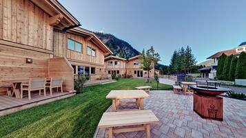 Een houten gebouw met een patio, compleet met tafels en stoelen.