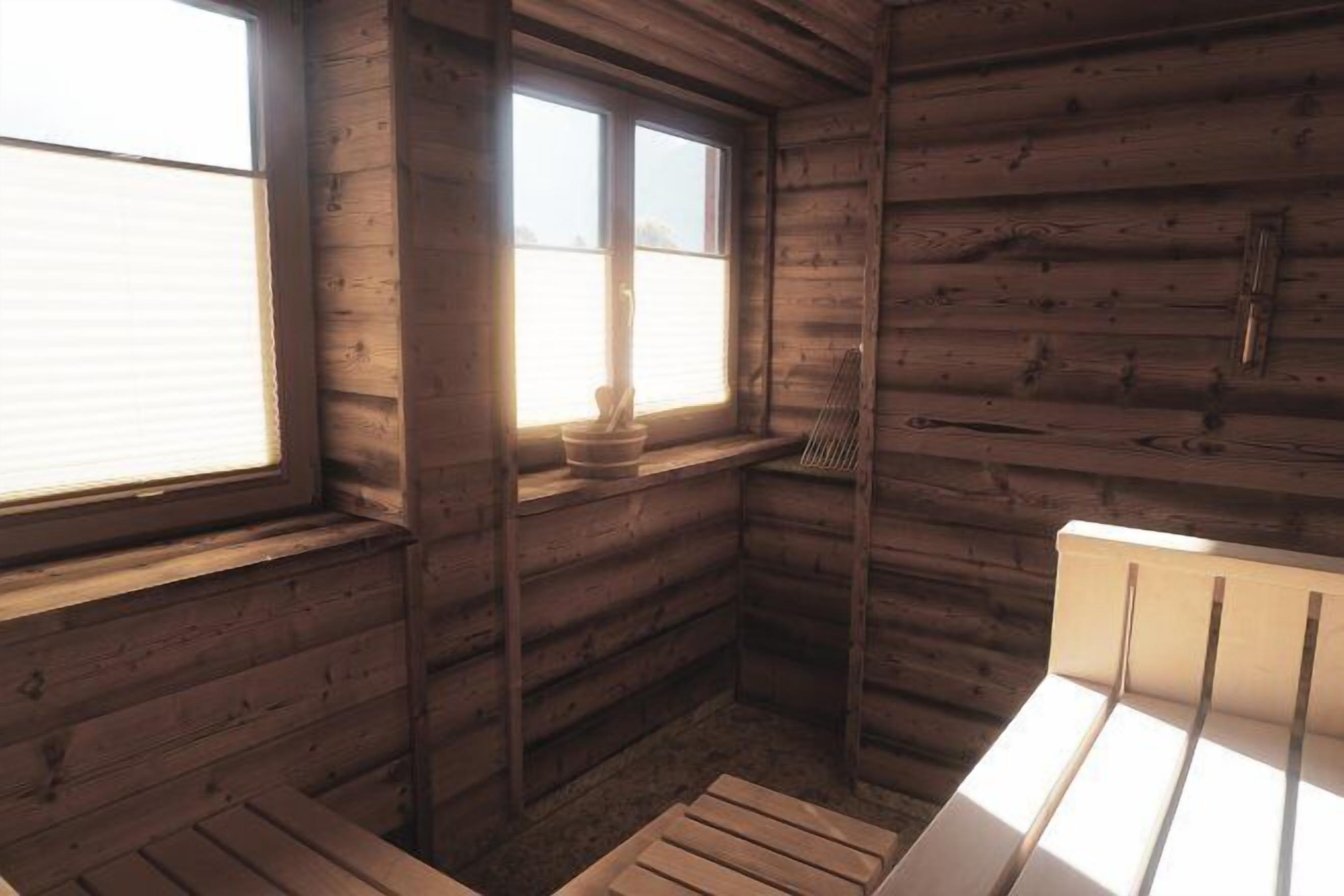 A cabin with a wooden interior, a window, a bench, and a small table with a candle.