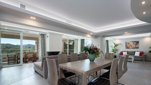 A spacious living area with a large dining table, comfortable seating, and a view of the outdoors. - Gem Villa in Viros Corfu  (Corfu)