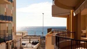 A balcony with a view of the sea, a parking area, and a building facade with balconies. - Beachfront apartment in Residence Rosa Virginia Pool (Gallipoli)