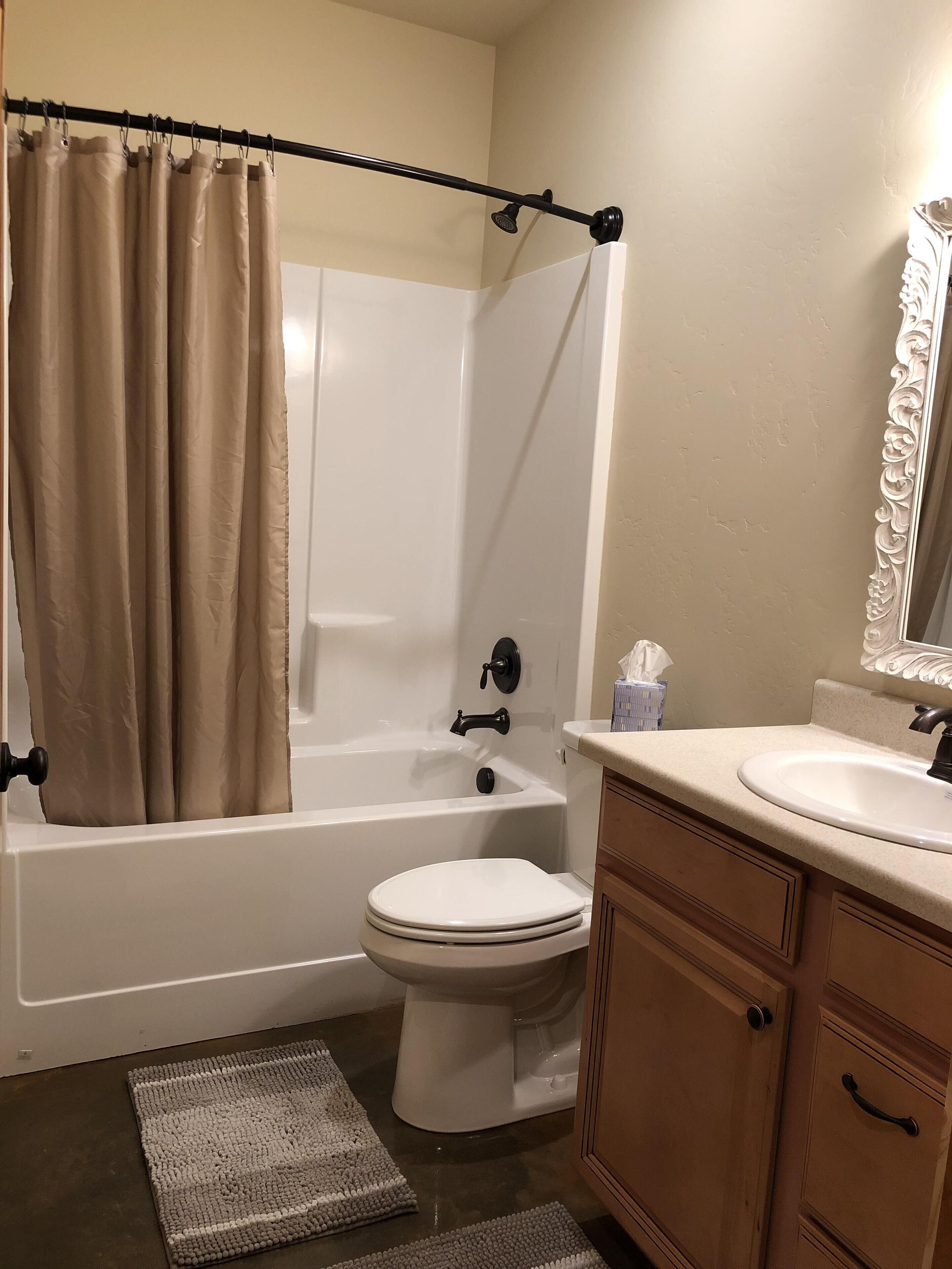 Un baño con bañera, inodoro y tocador.