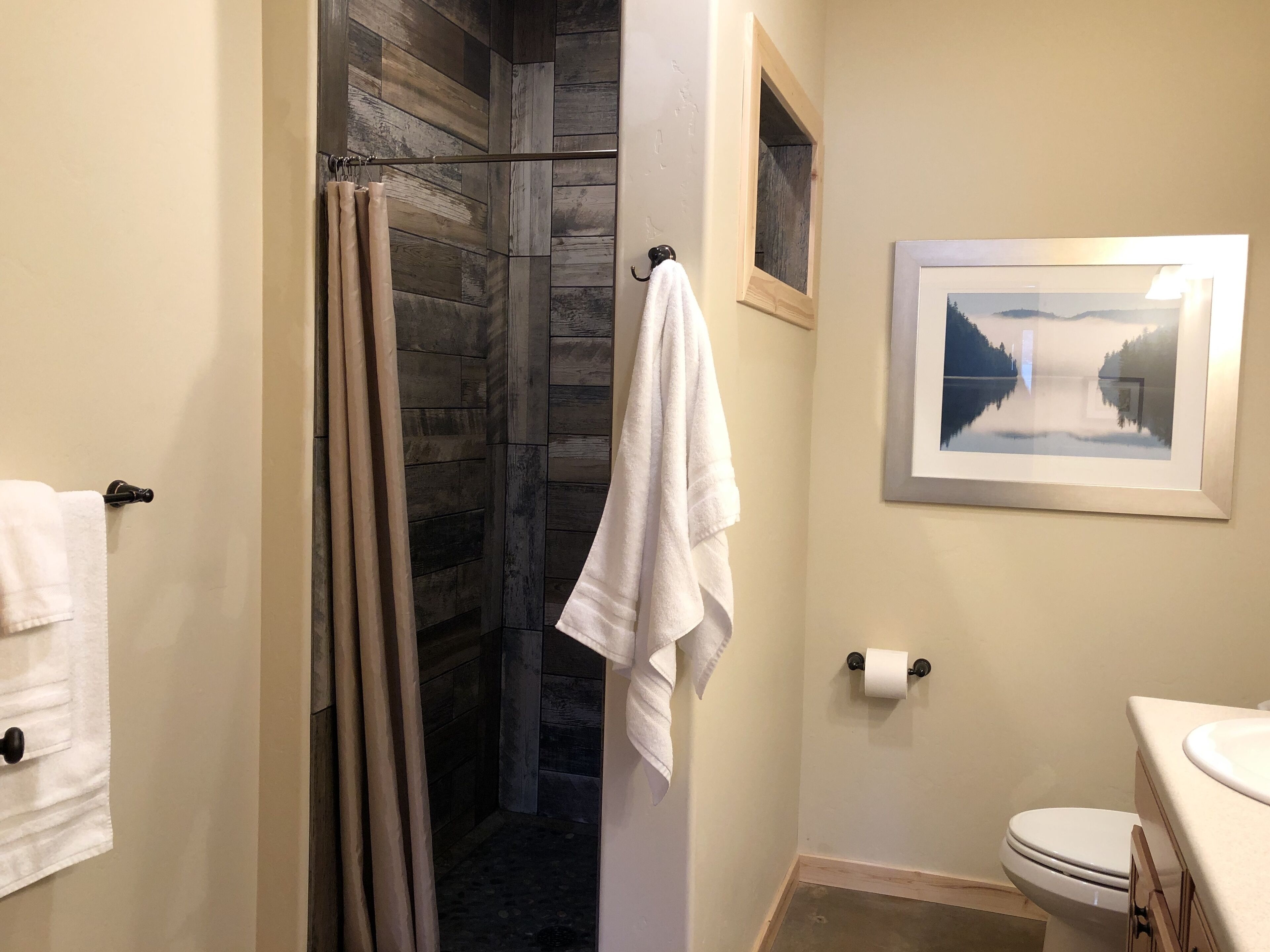 A bathroom with a shower, toilet, and sink.