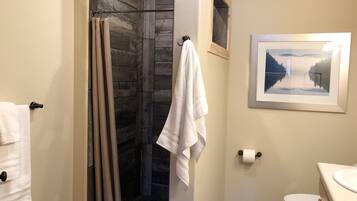 A bathroom with a shower, toilet, and sink.