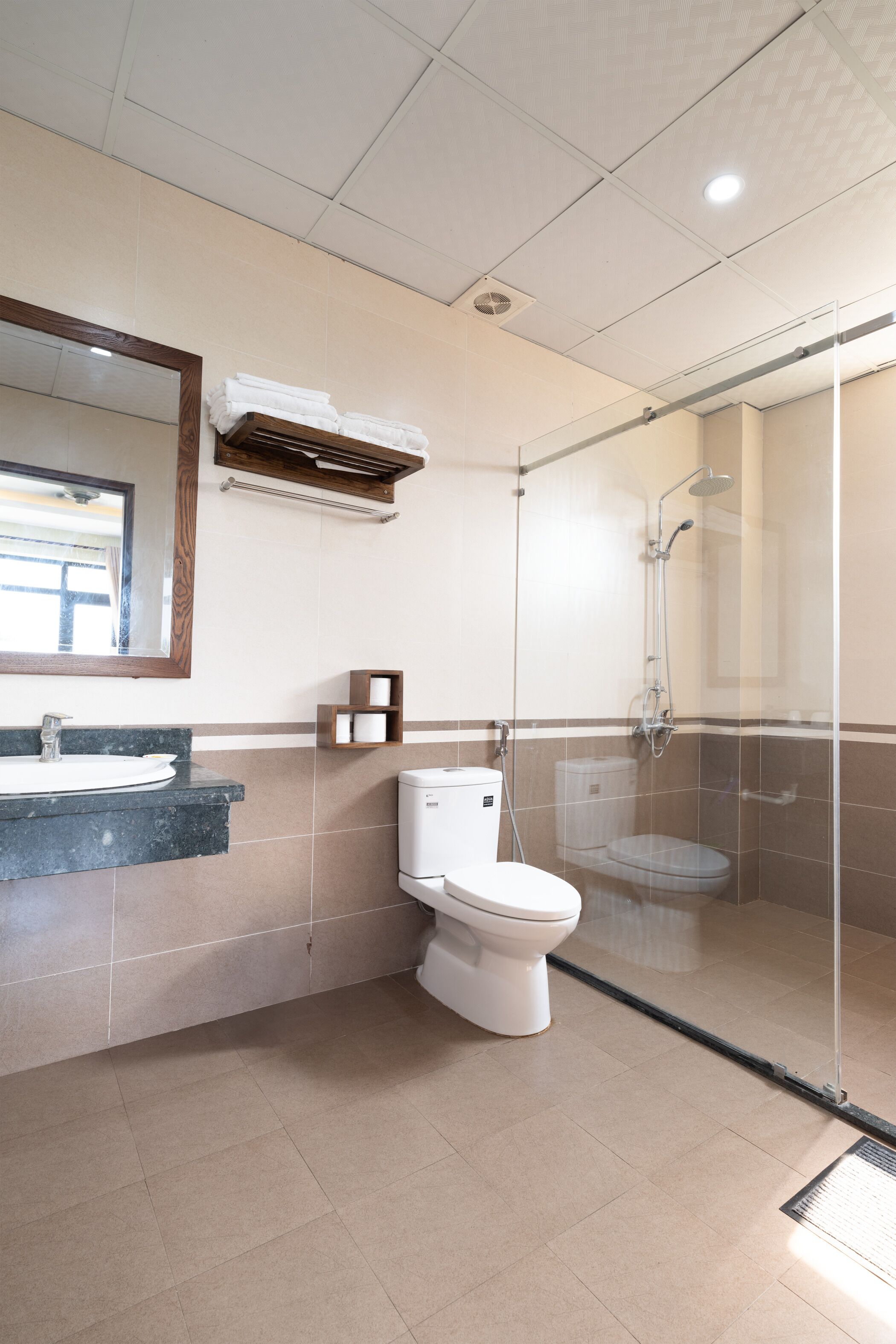 A bathroom with a glass-enclosed shower, a sink with a mirror, and a toilet.