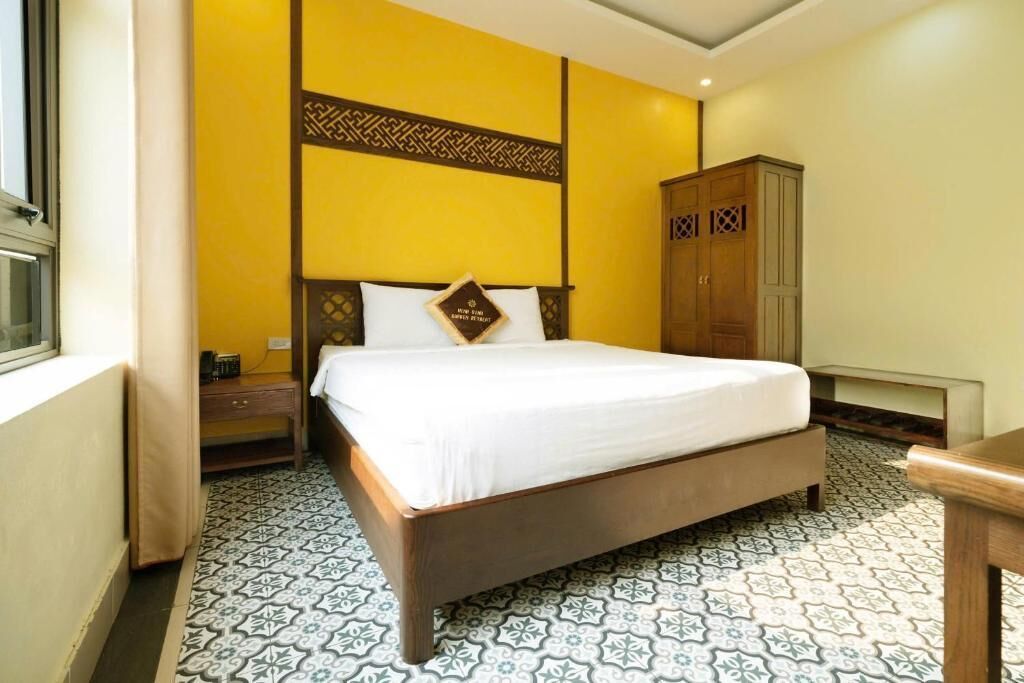 Un dormitorio con cama, armario y suelo estampado.