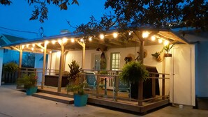 A covered outdoor patio with string lights, potted plants, and outdoor furniture. - VINTAGE BEACH COTTAGE
BOOK NOW! SAVE!!
90 sec. walk to beach!
Supplies Included! (North Myrtle Beach)