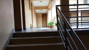 Una escalera con barandilla metálica que lleva a una plataforma con una puerta al final.