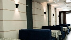 Une rangée de cabines bleu foncé, chacune équipée d’une table recouverte d’une nappe à motifs.