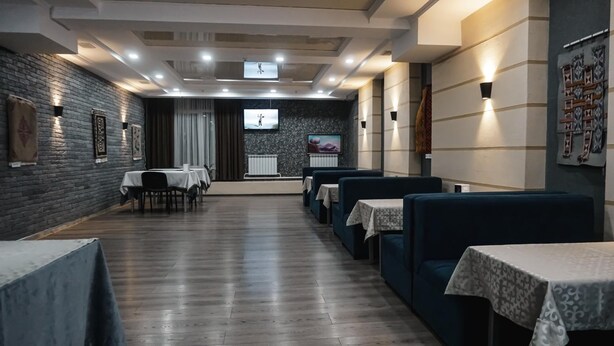 Un restaurant avec un long comptoir, des banquettes et un écran de télévision.