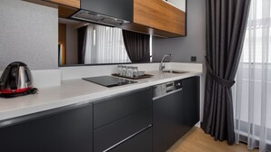 A modern kitchen with a built-in dishwasher, a kettle, and a mirror above the counter. - Nox Suite (Antalya)