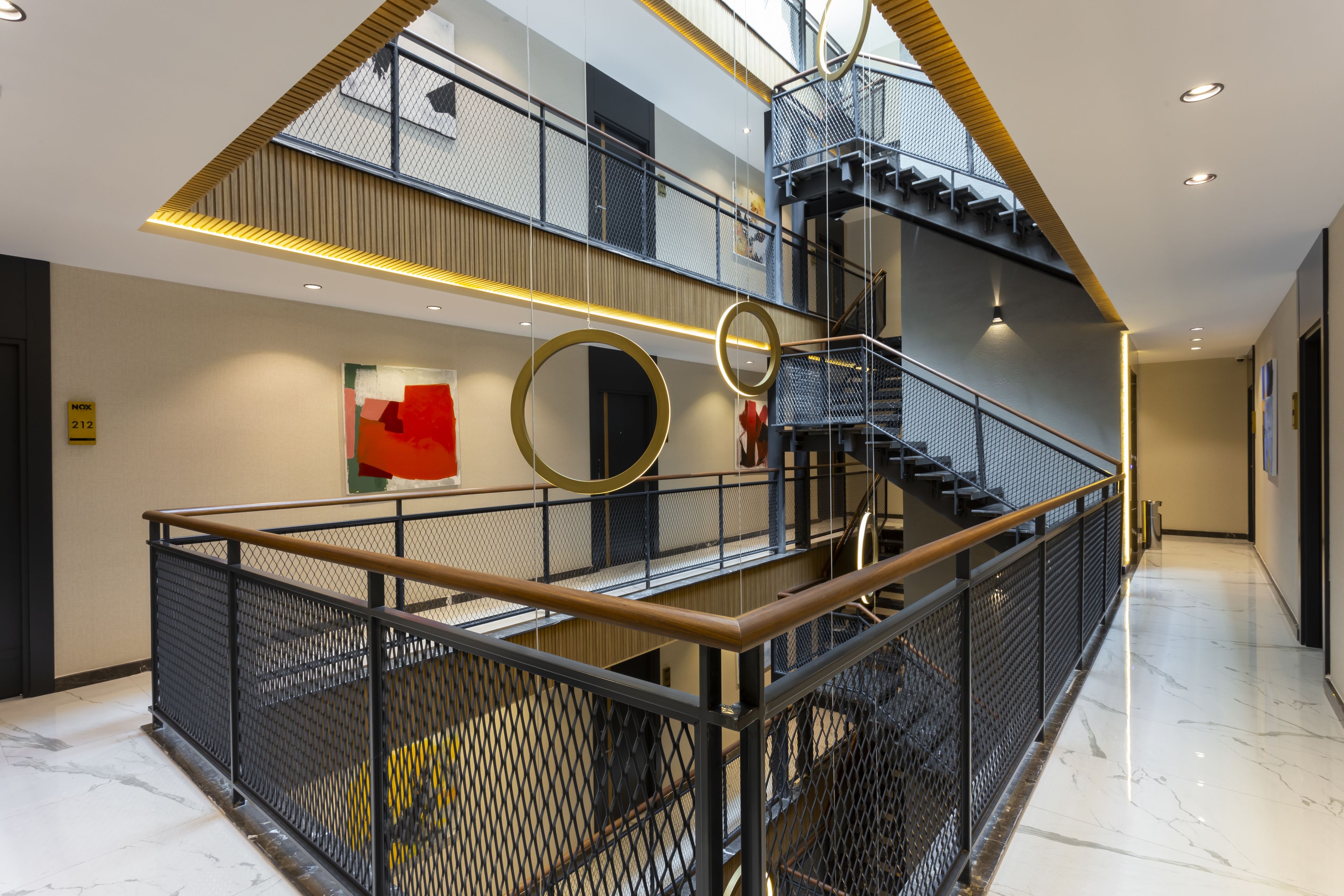 A multi-level interior with a central spiral staircase, metal railings, and a modern design.