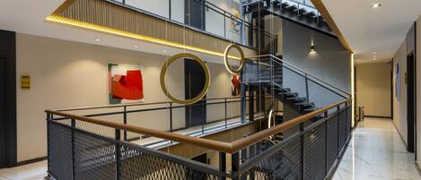A multi-level interior with a central spiral staircase, metal railings, and a modern design.