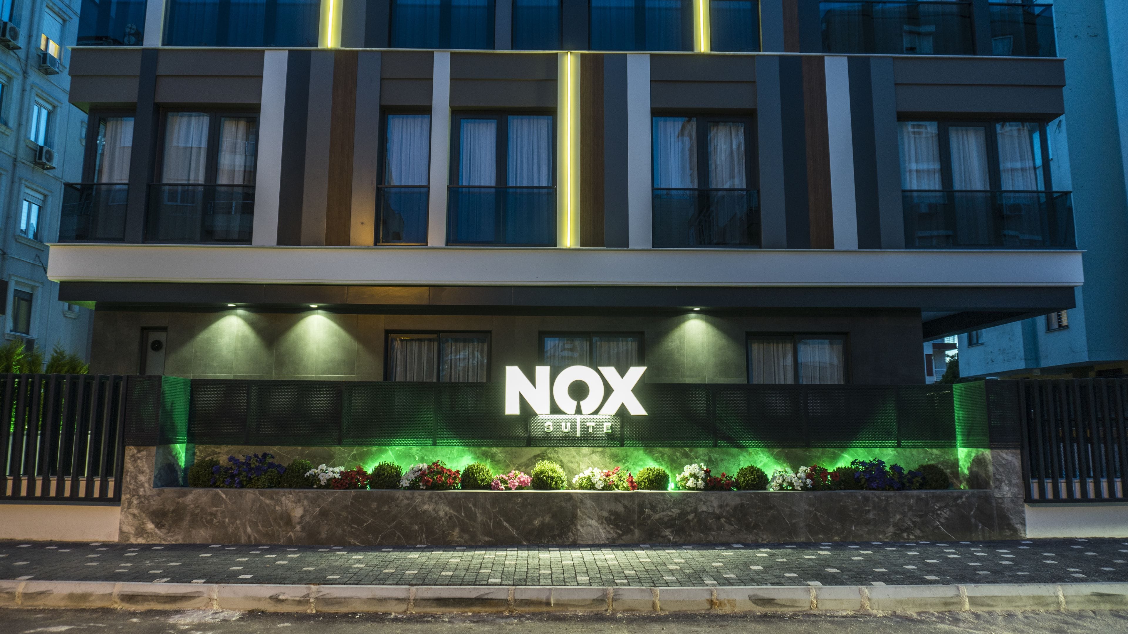 A modern building with a sign reading "NOX SUITE".